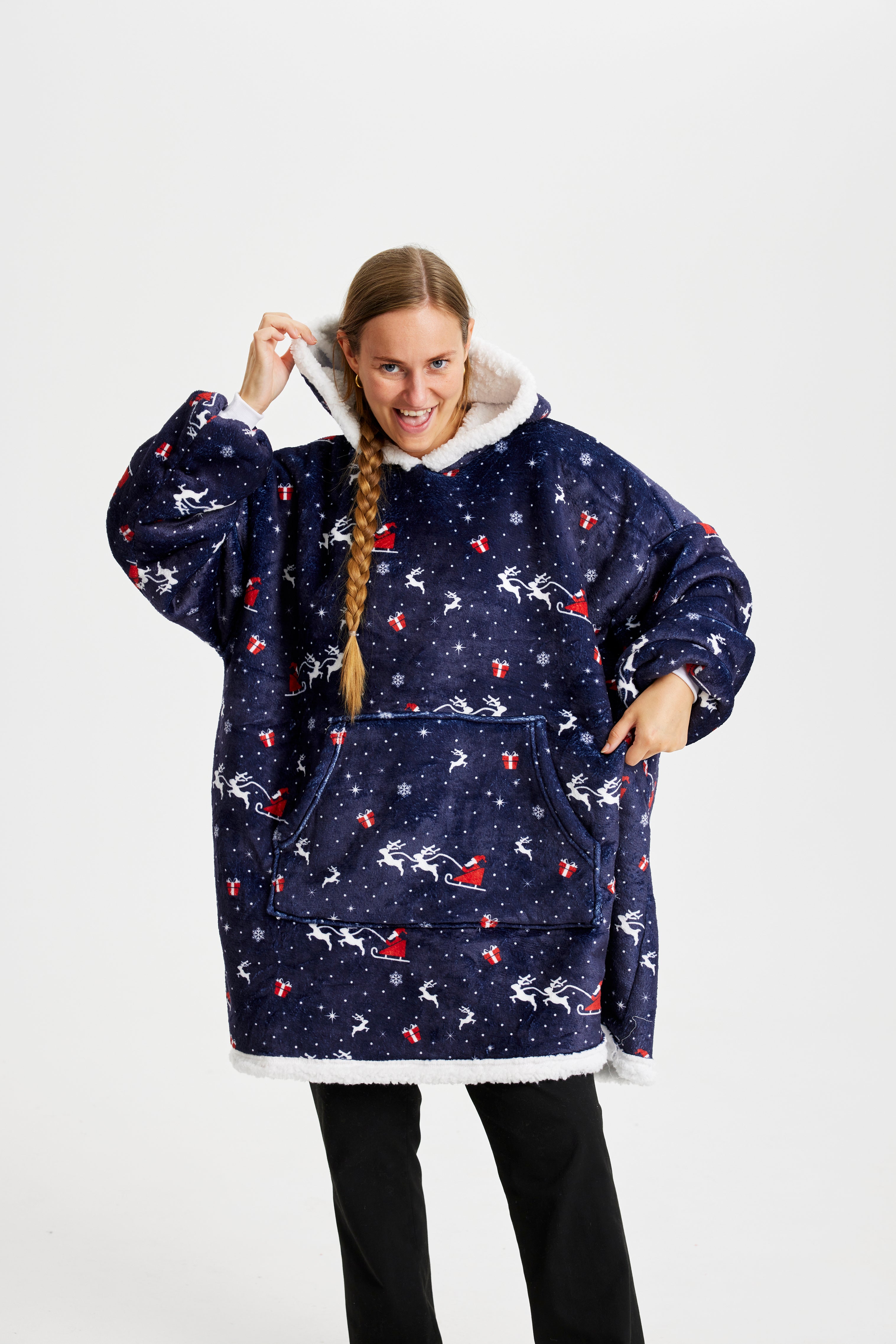 En smilende kvinne med blå julegenser med reinsdyr på.